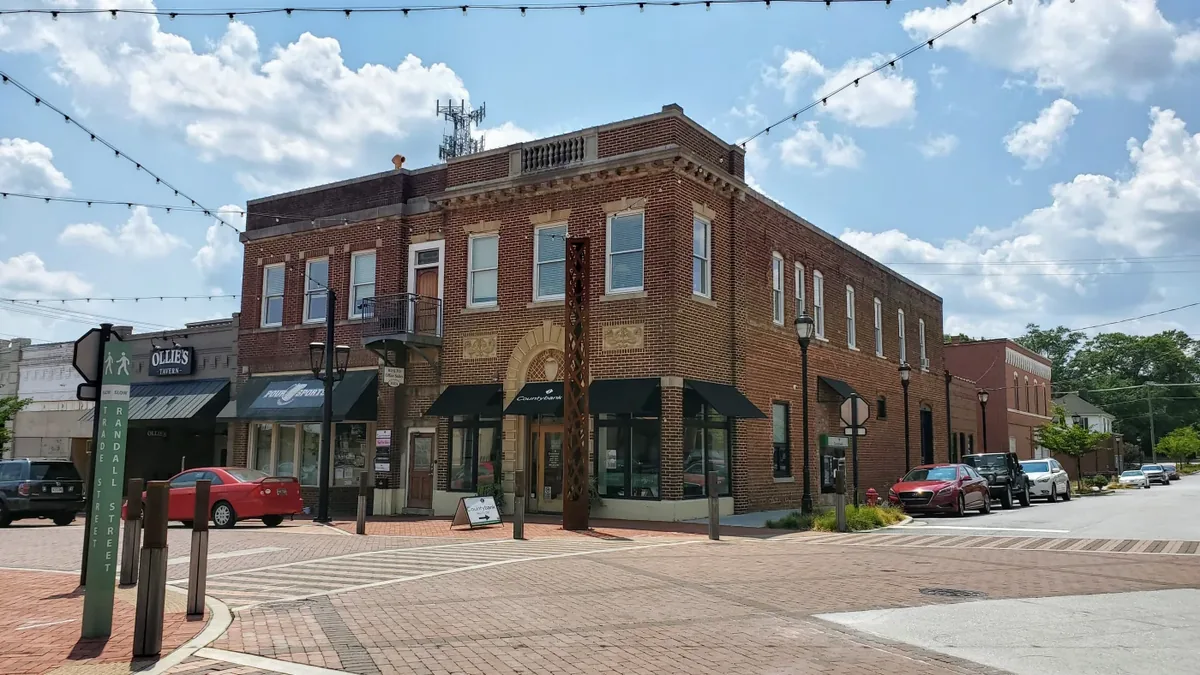 Historic brick storefronts and overhead string lights on Trade Street in downtown Greer